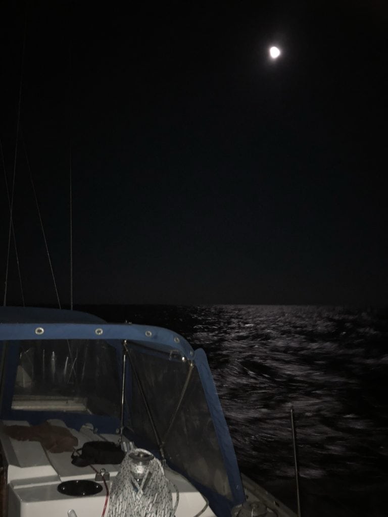 a boat in the middle of the night, in the middle of the ocean