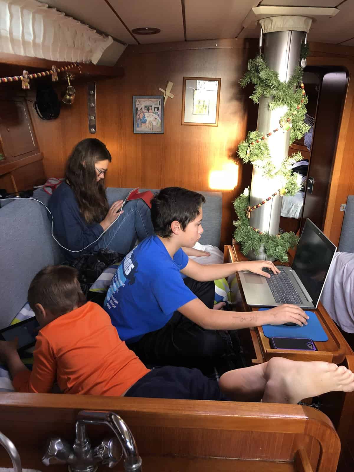 kids on their devices, in the salon, on a sailboat
