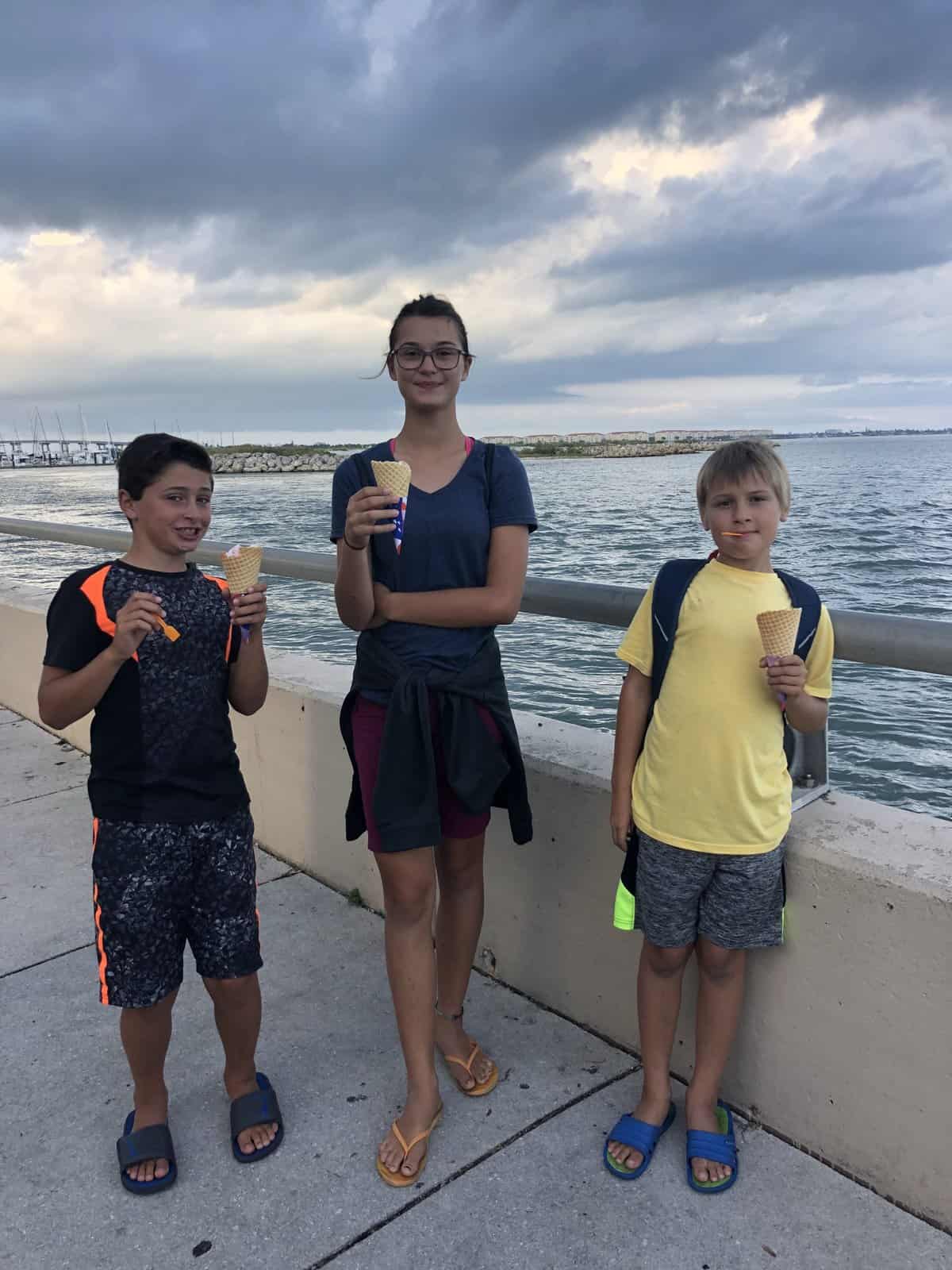 three kids eating ice cream at the dock