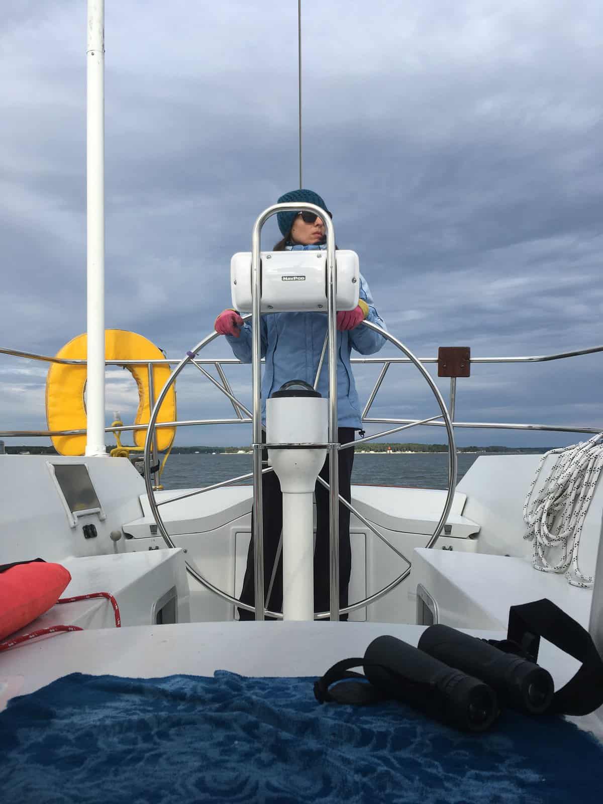 a woman at the helm of a sailboat