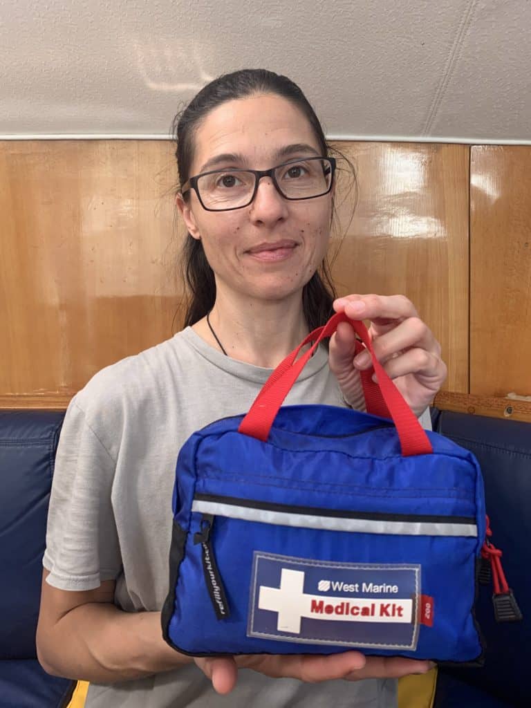a woman holding a small trave first aid kit bag