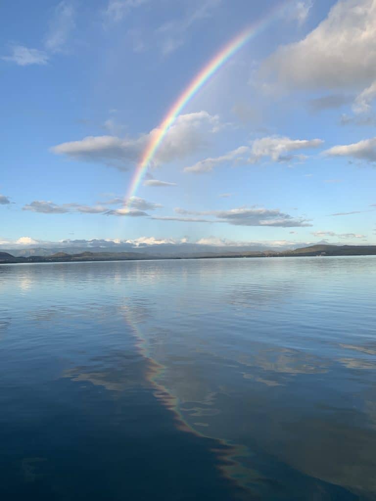 View of our reef anchorage close to the Bio Bay, showing beautiful rainbow starting in the sky and continuing into the calm water.