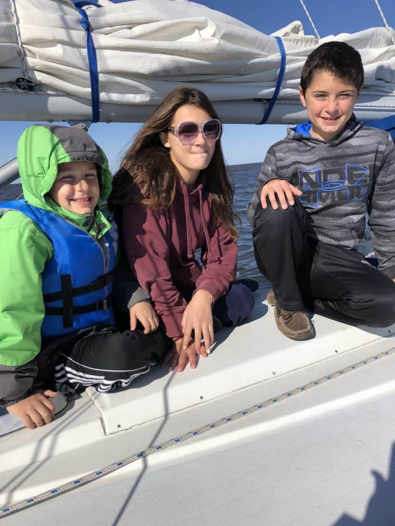 three kids on a sailboat