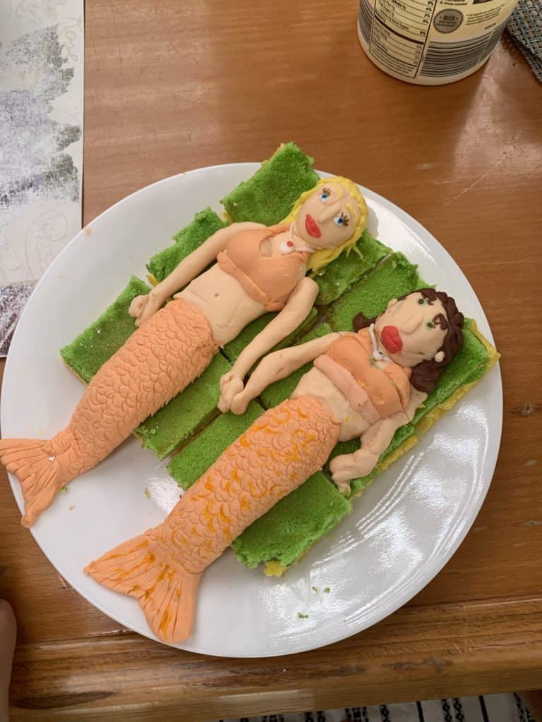 two mermaid cakes with funny faces, on a sailboat