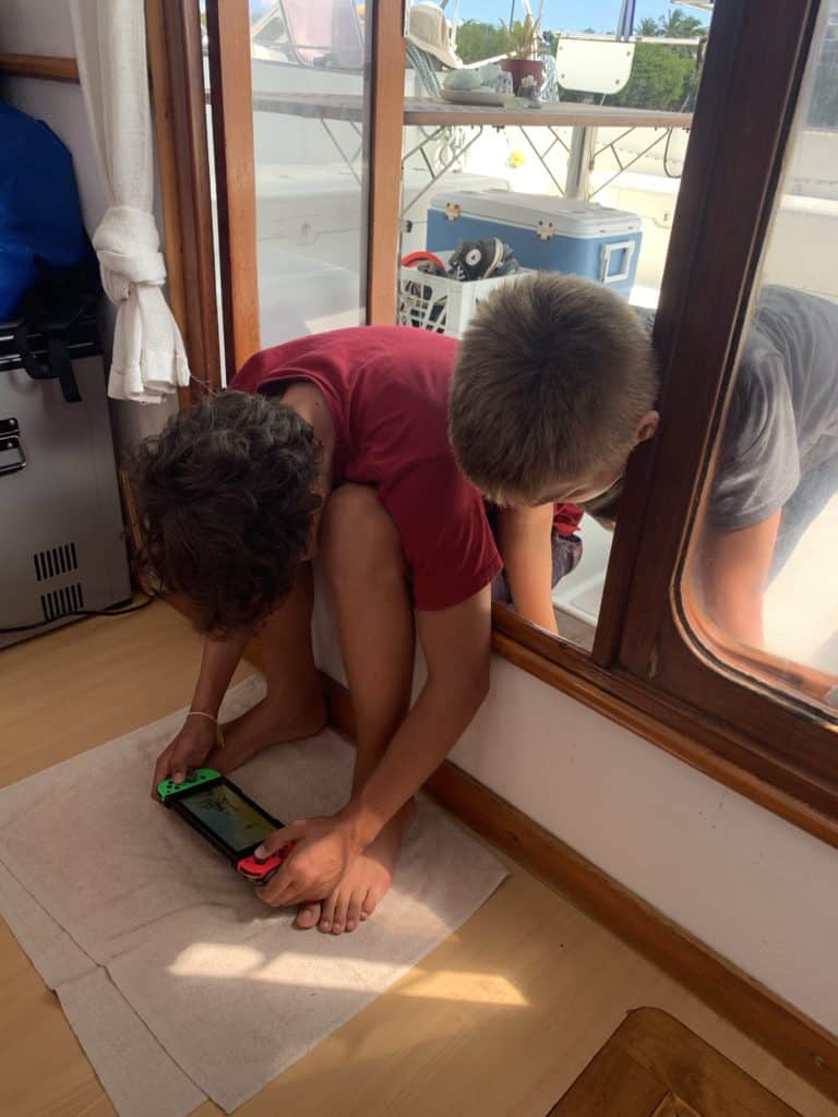 boys playing a Nintendo Switch video game aboard
