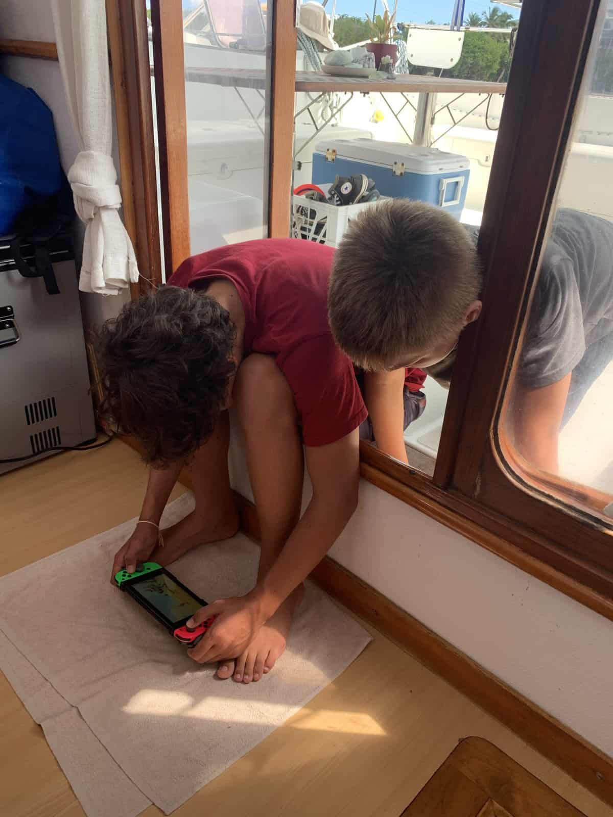 boys playing a video game aboard