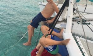 kids at the bow of a catamaran, making funny faces