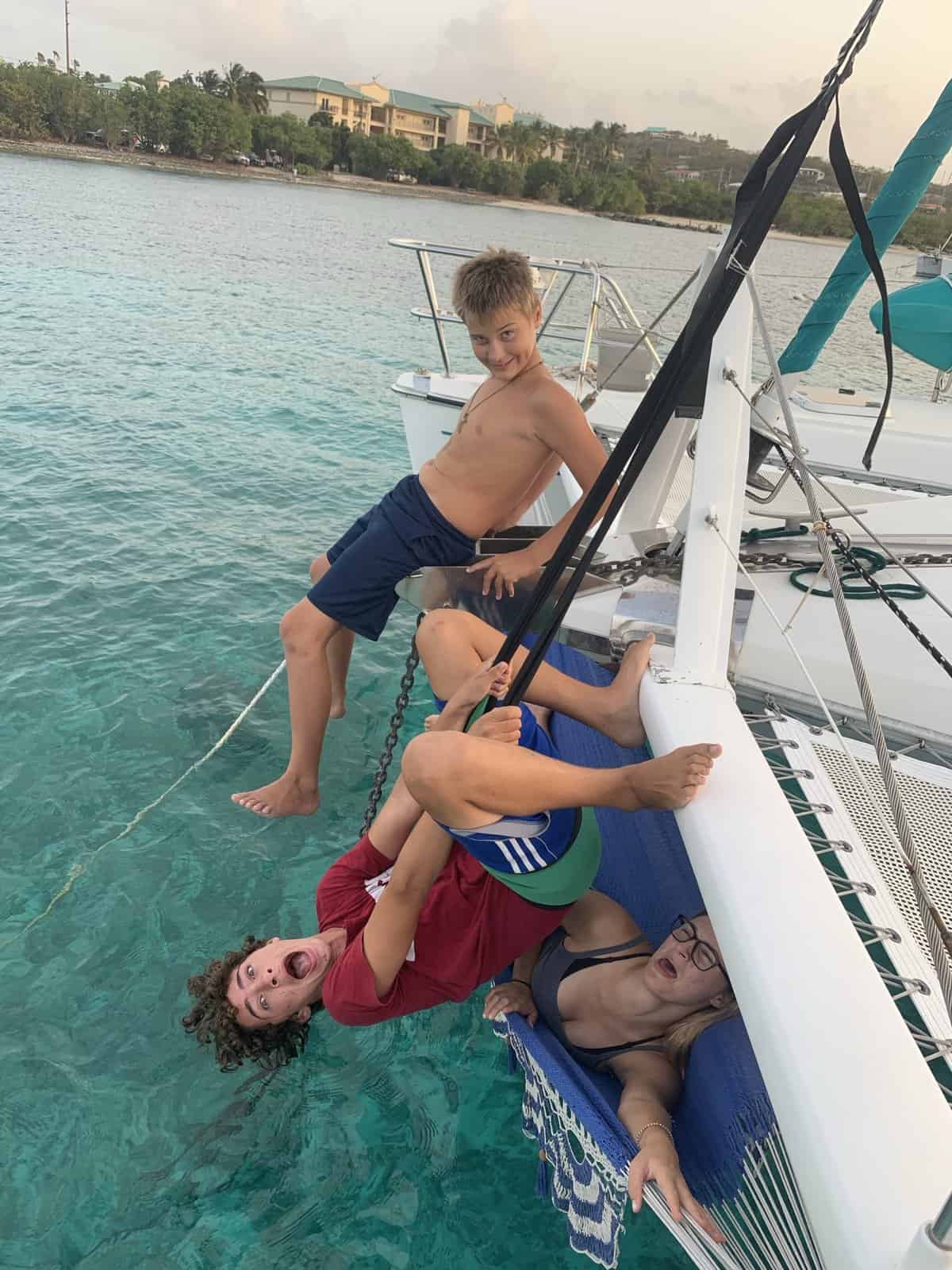 kids at the bow of a catamaran, making funny faces