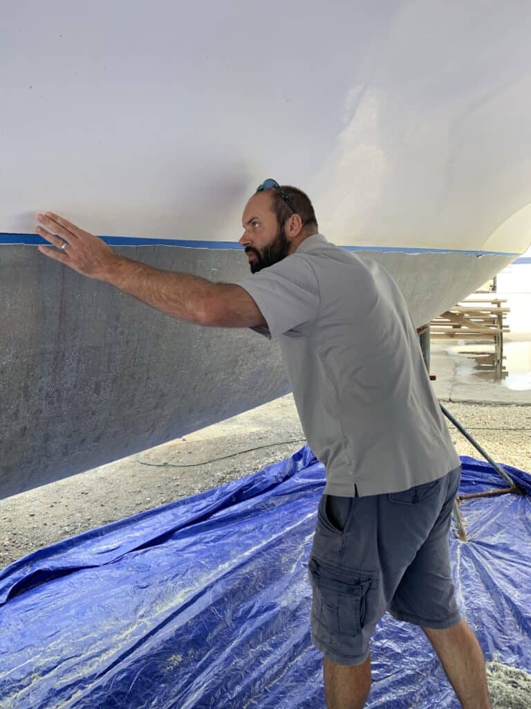 Joe inspecting the new fiberglass layer on the boat