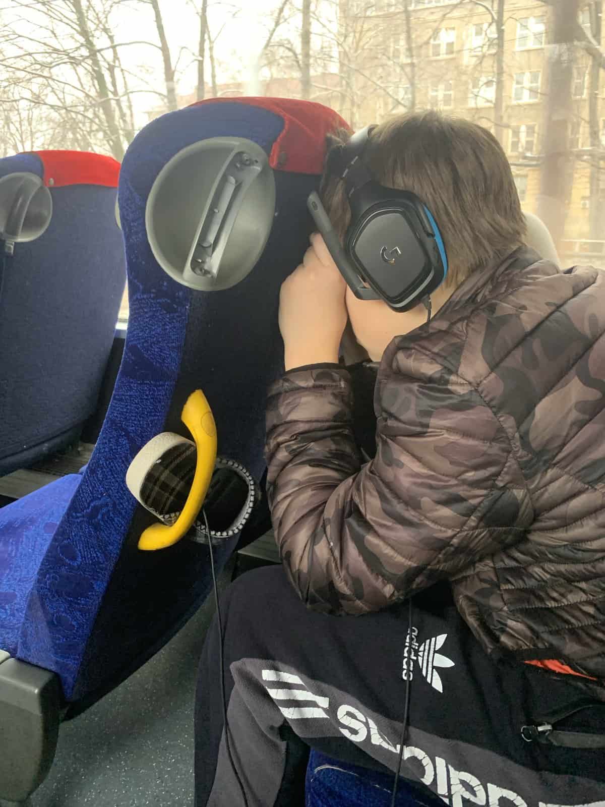 a child sleeping on a bus with large headphones on