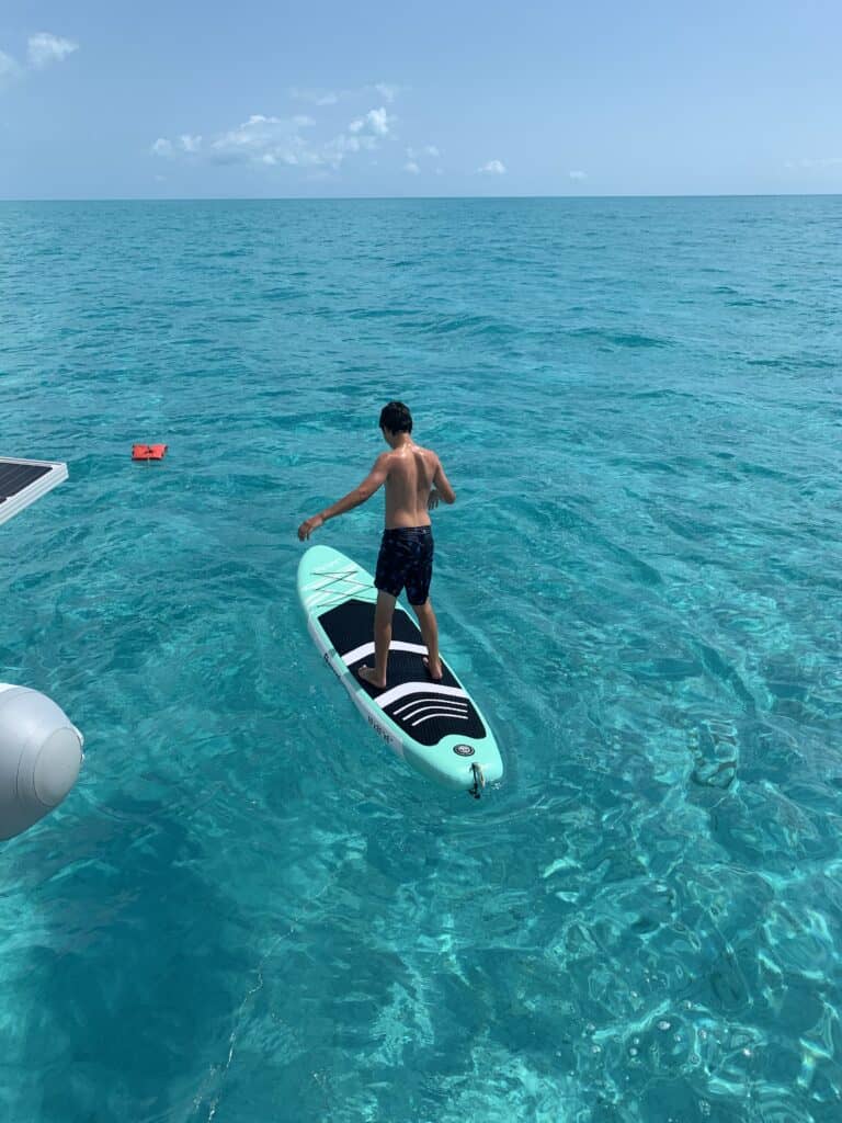 a boy on a paddleboard in the ocean. paddleboards are fun gifts for boaters
