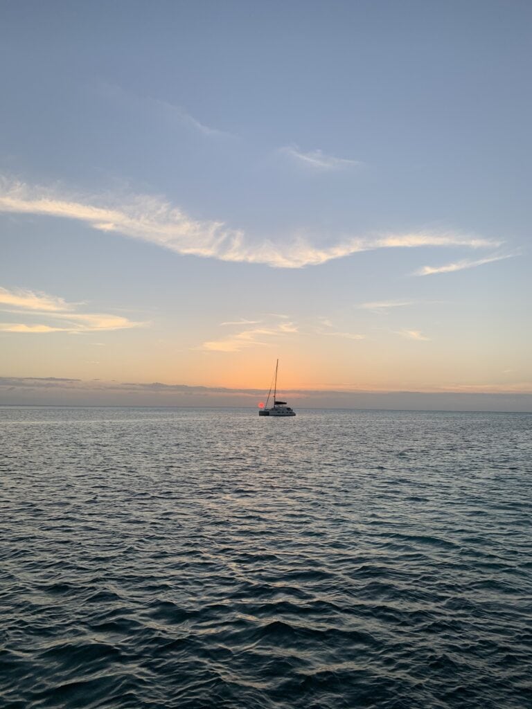 A single boat in an anchorage at sunset