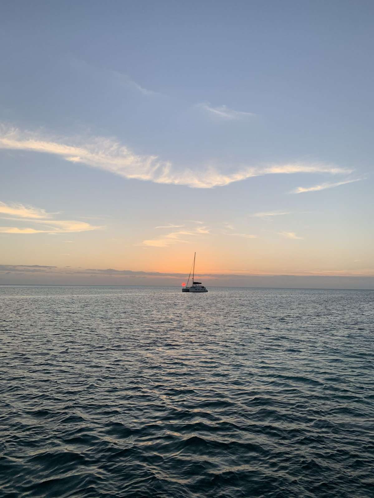 A single boat in an anchorage at sunset